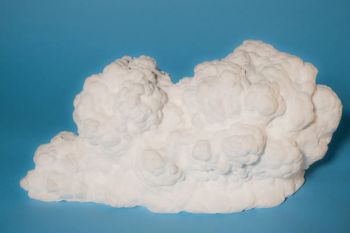 The full plaster sculpture Nine: a white, billowing cumulus cloud resting on its flat base against a blue backdrop.
